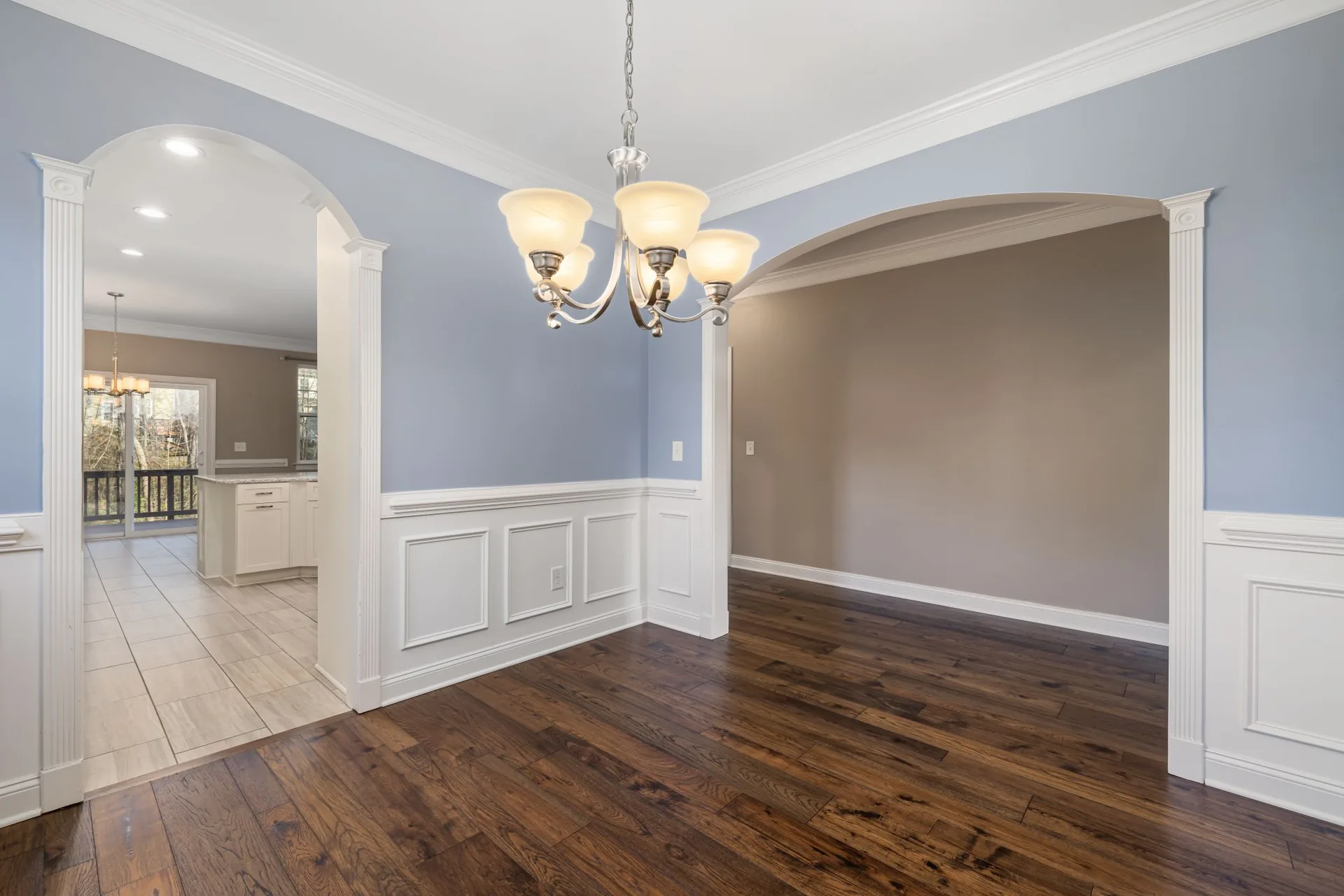 Freshly painted living room with blue-gray walls and white wainscot trim