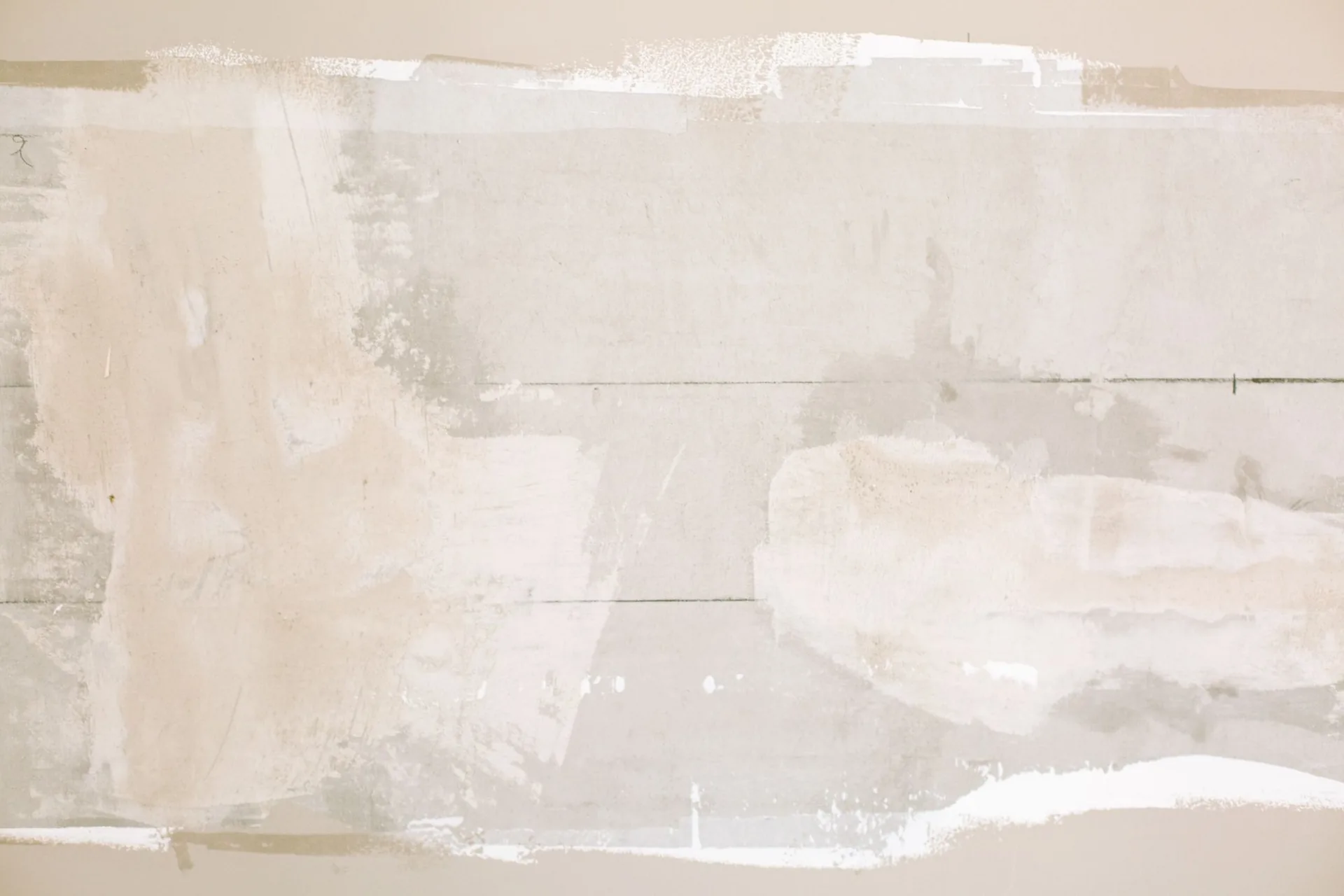 Patched and skim-coated drywall wall ready for sanding